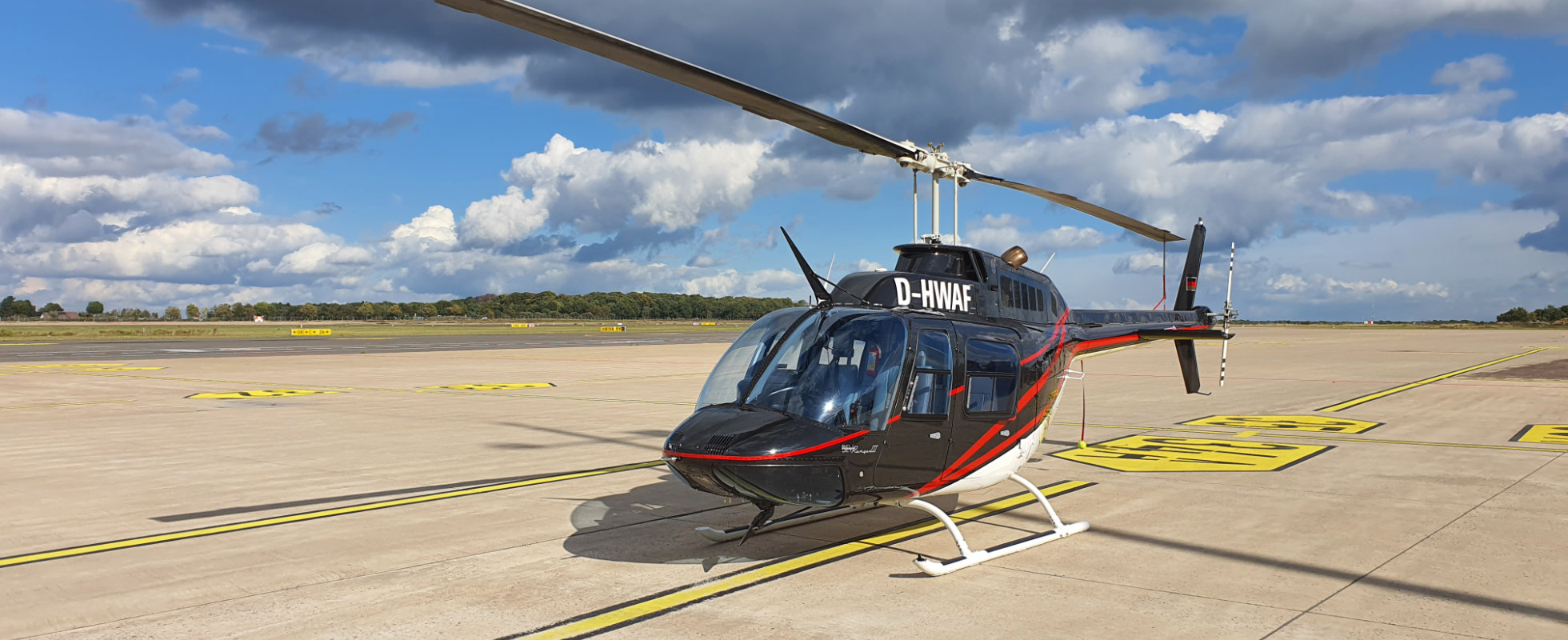 Schwarzer Hubschrauber des HeliPort Sulingen auf dem Flugfeld